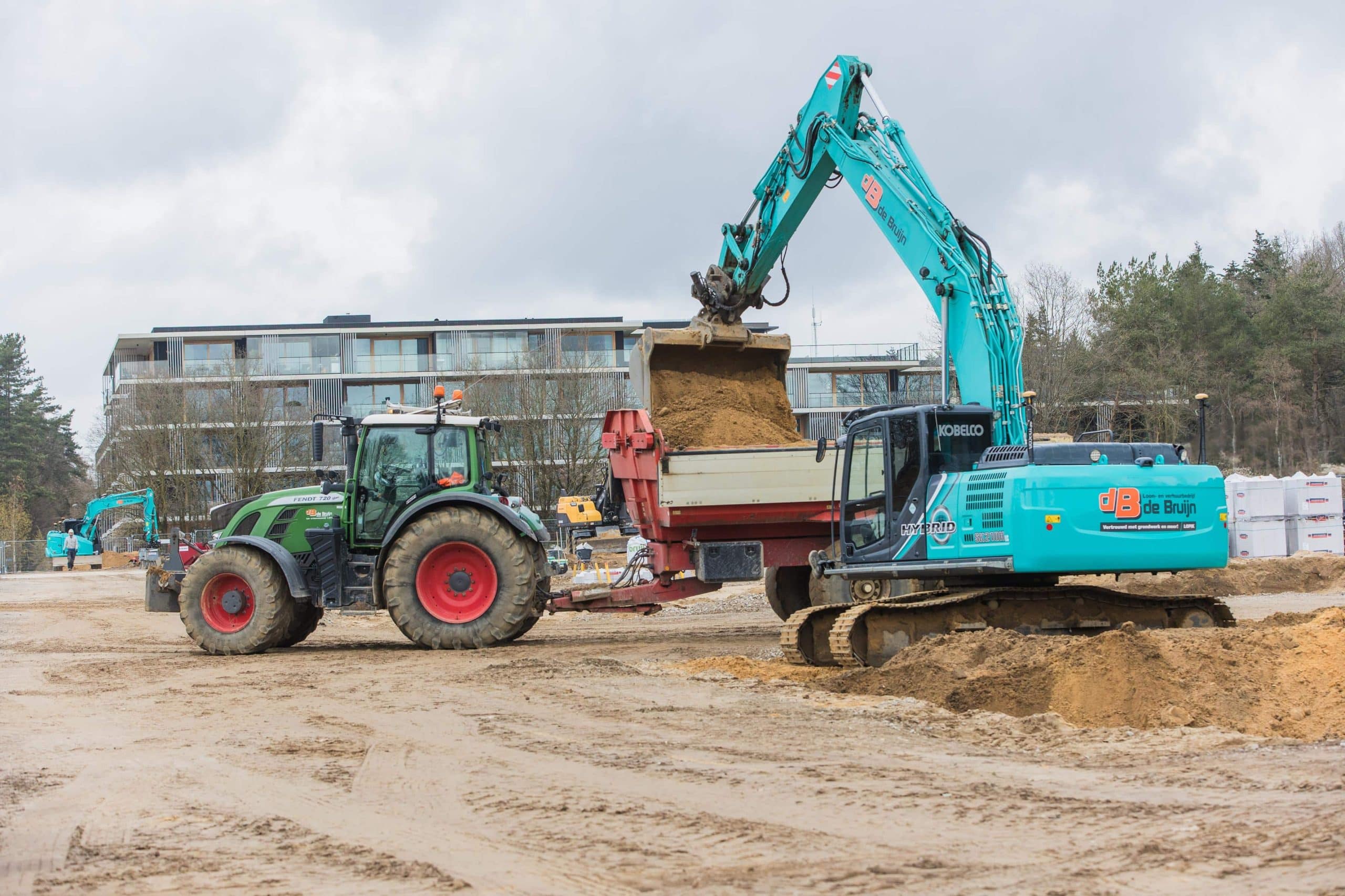 Graafmachine laadt zand in een vrachtwagen bij grondwerk