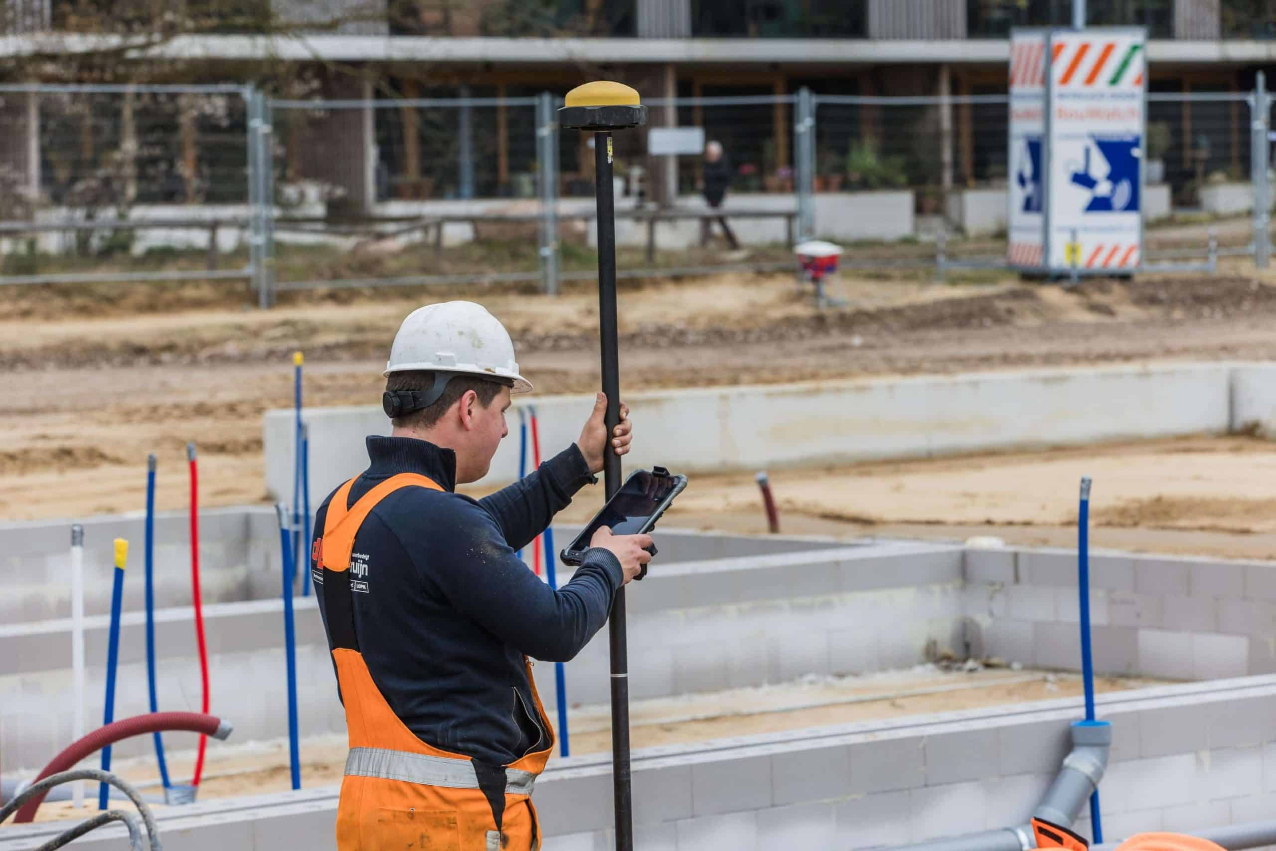 Landmeter voert metingen uit op bouwplaats voor infrastructureel project