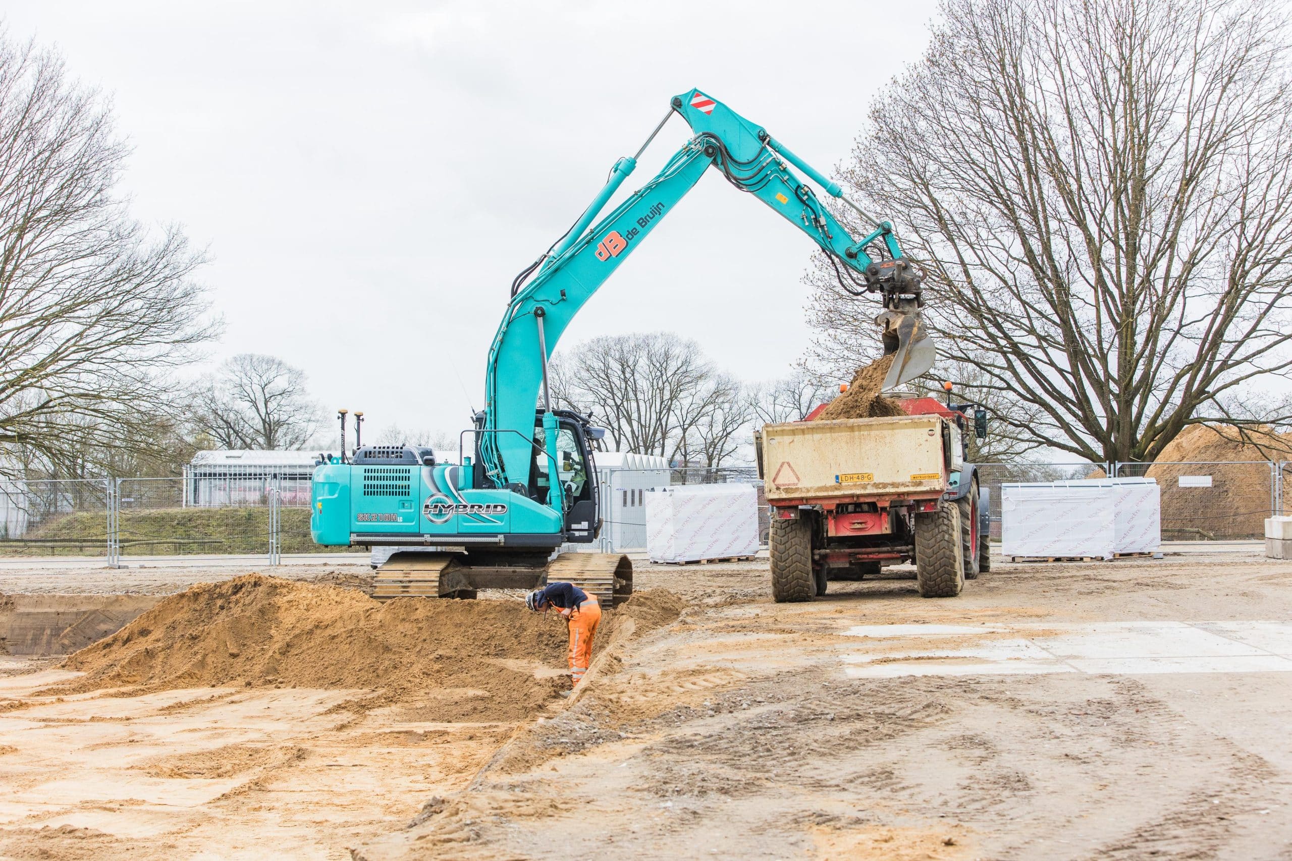 Rupskraan laadt zand in een vrachtwagen op een bouwplaats
