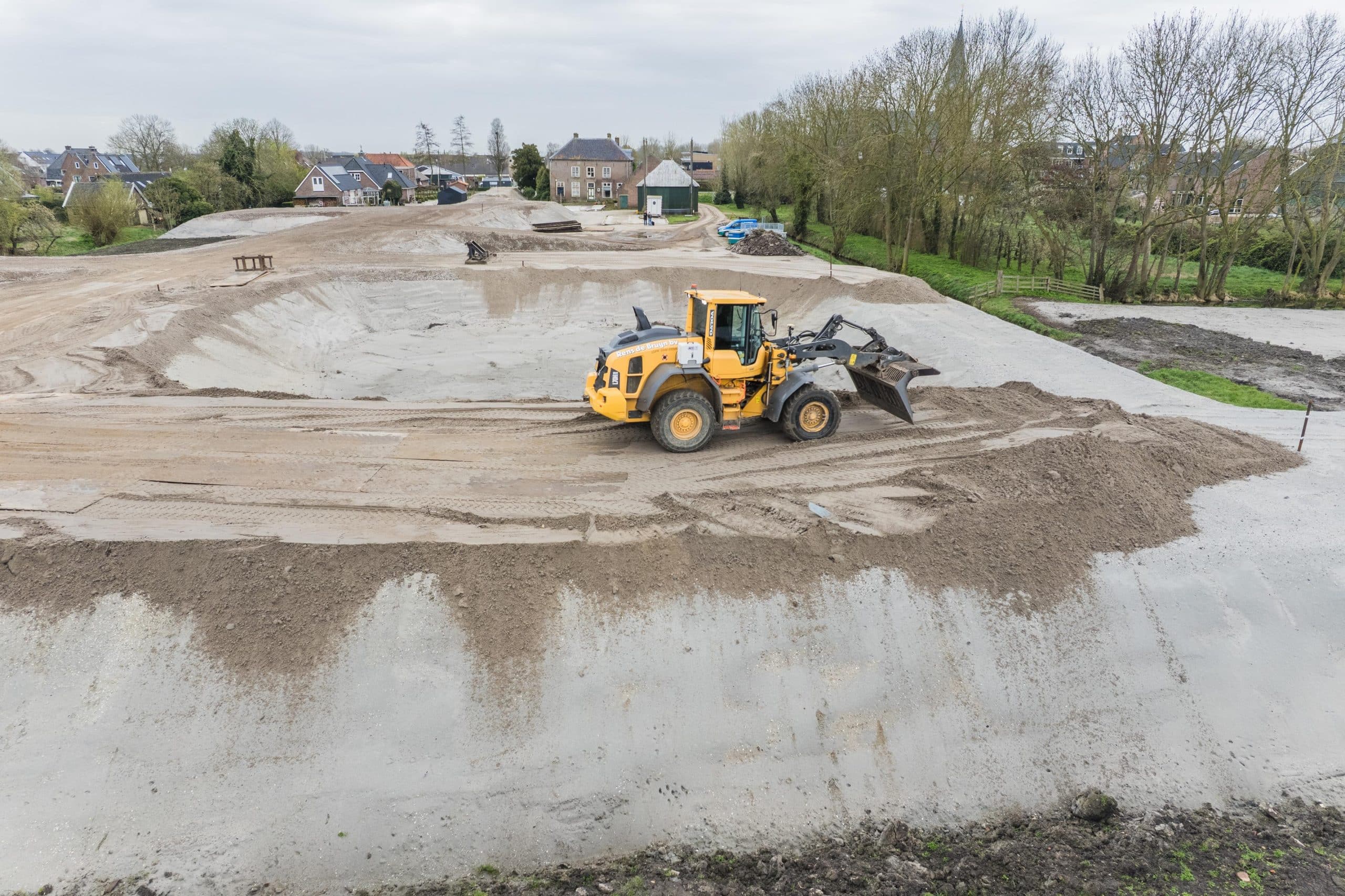 Shovel werkt aan terreinverharding op groot bouwterrein